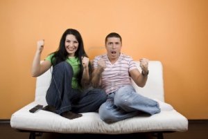 4256671-happy-couple-home-watching-tv-their-favorite-sport-team-or-favorite-match-over-television-and-they-e